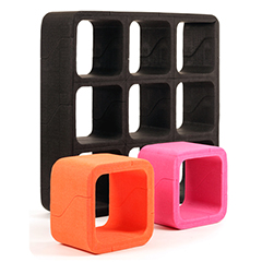 A black ARPRO (expanded polypropylene) shelving system at the back of the image, with a smaller orange and magenta cube at the front made by Movisi