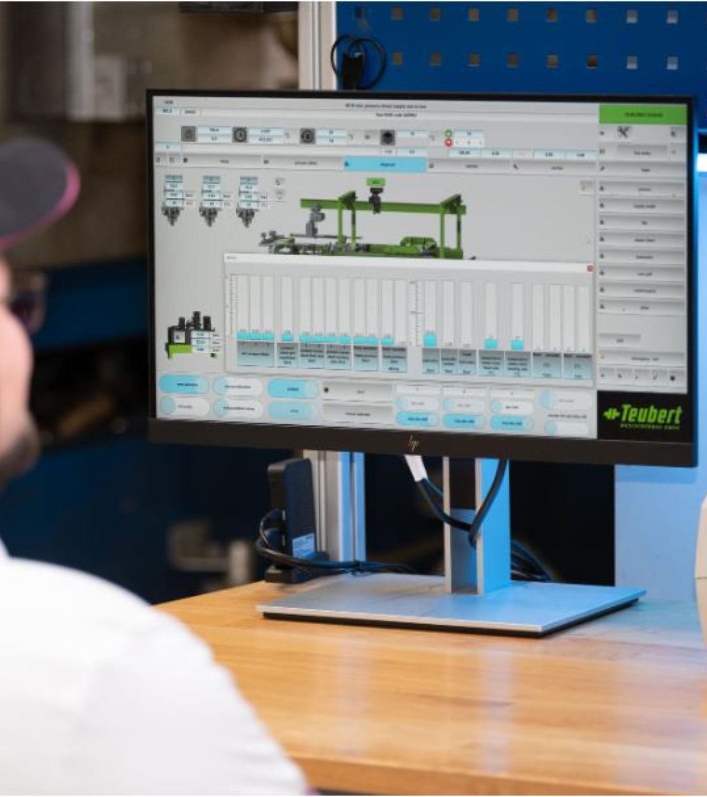 Close-up of man looking at a screen that shows the stats from a telemetric moulding facility.