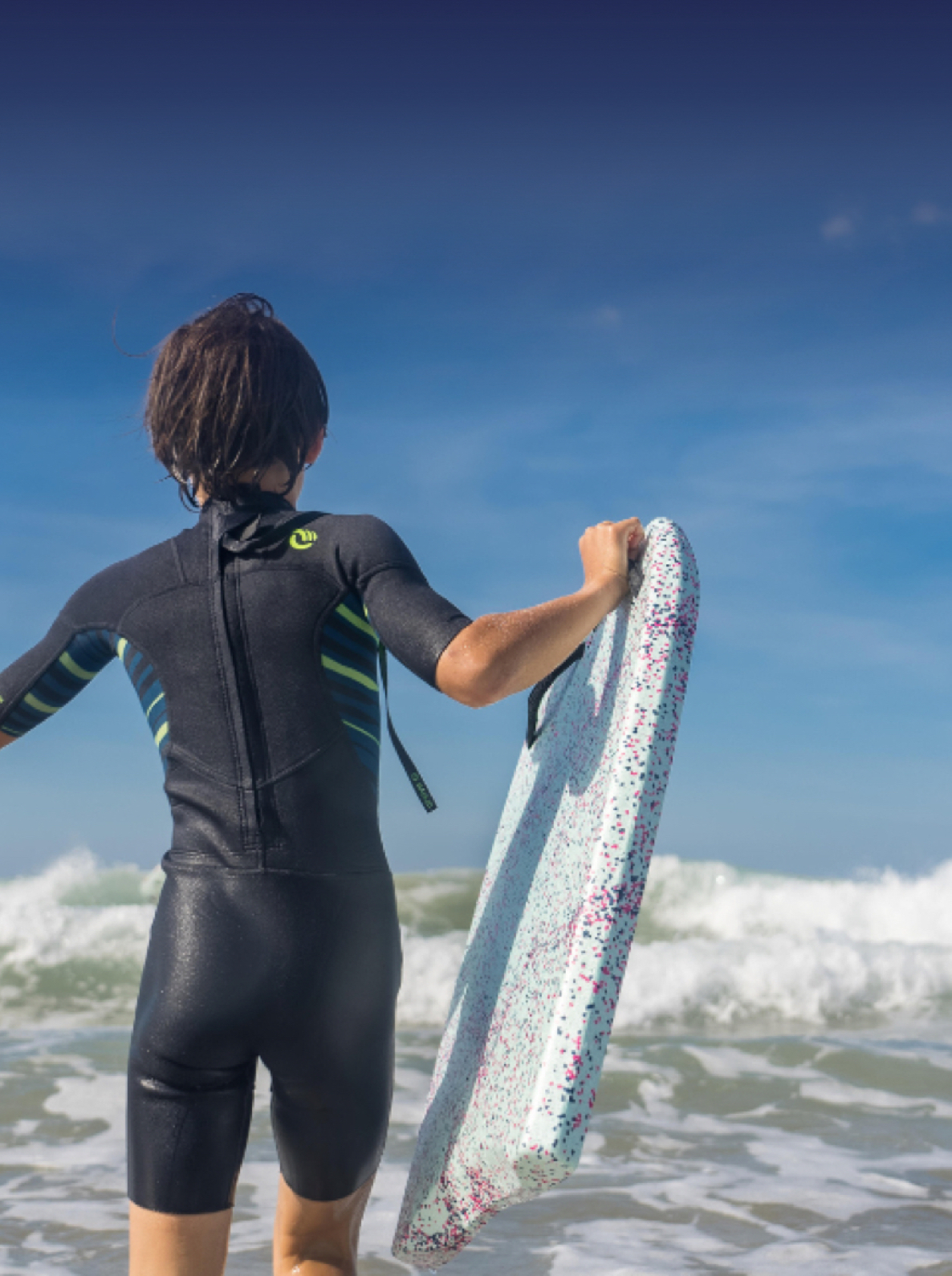 A child in a black wet suit with a body board made from ARPRO 35 Ocean