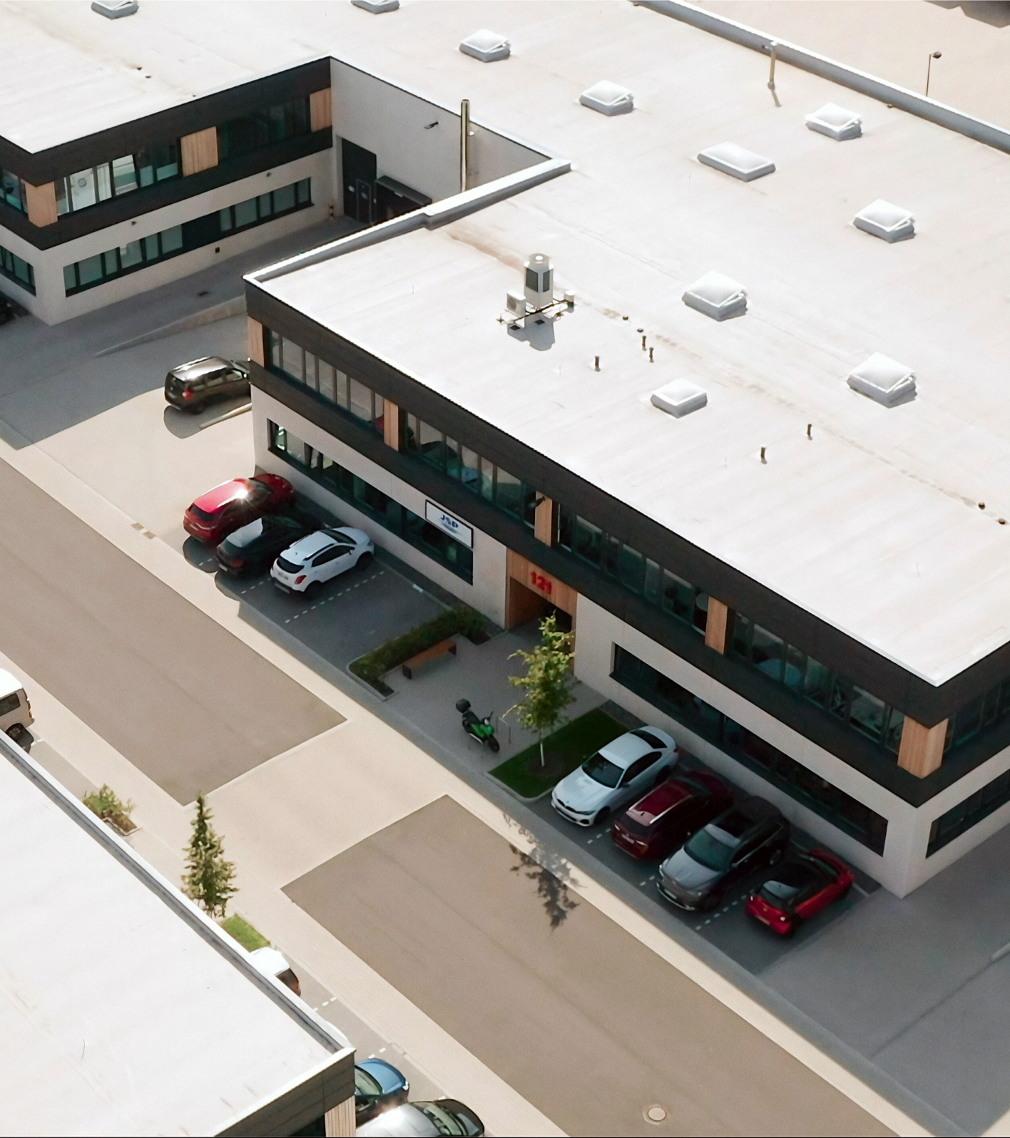 An aerial view of the JSP Innovation Centre with cars parked outside.