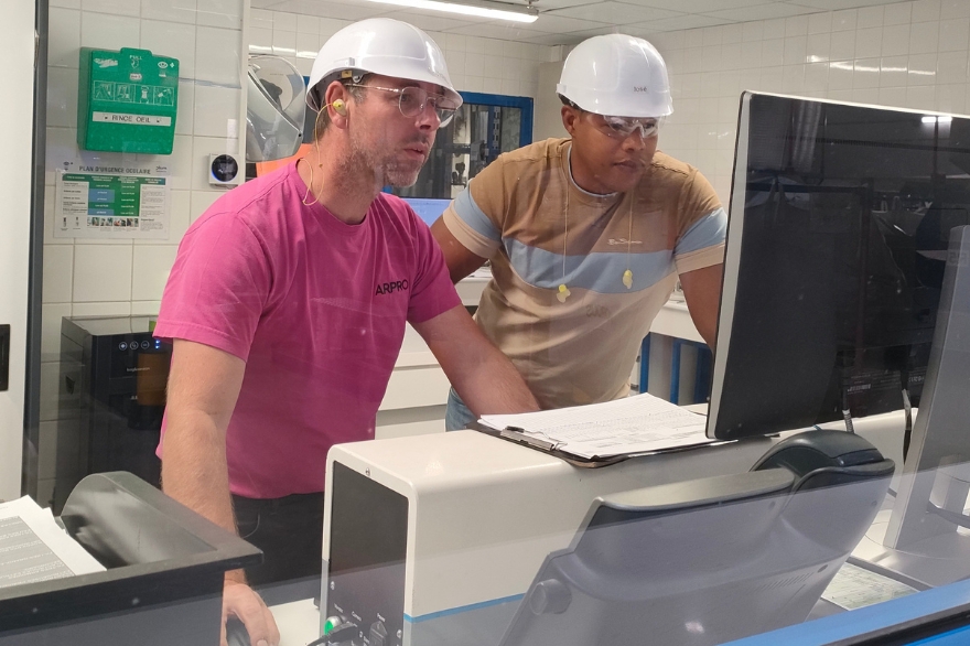 Two gentleman in a lab in a JSP factory looking at a computer screen for quality management