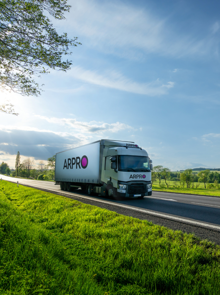 A white lorry with an ARPRO logo driving through green countryside